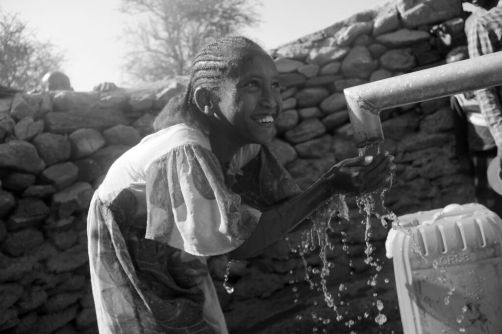 Girl drinking water from well